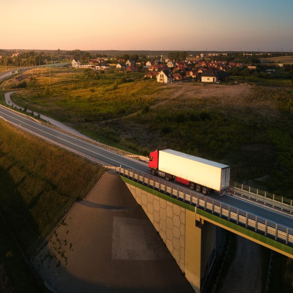 Autonomous truck over a bridge represents the middle mile in freight transportation.