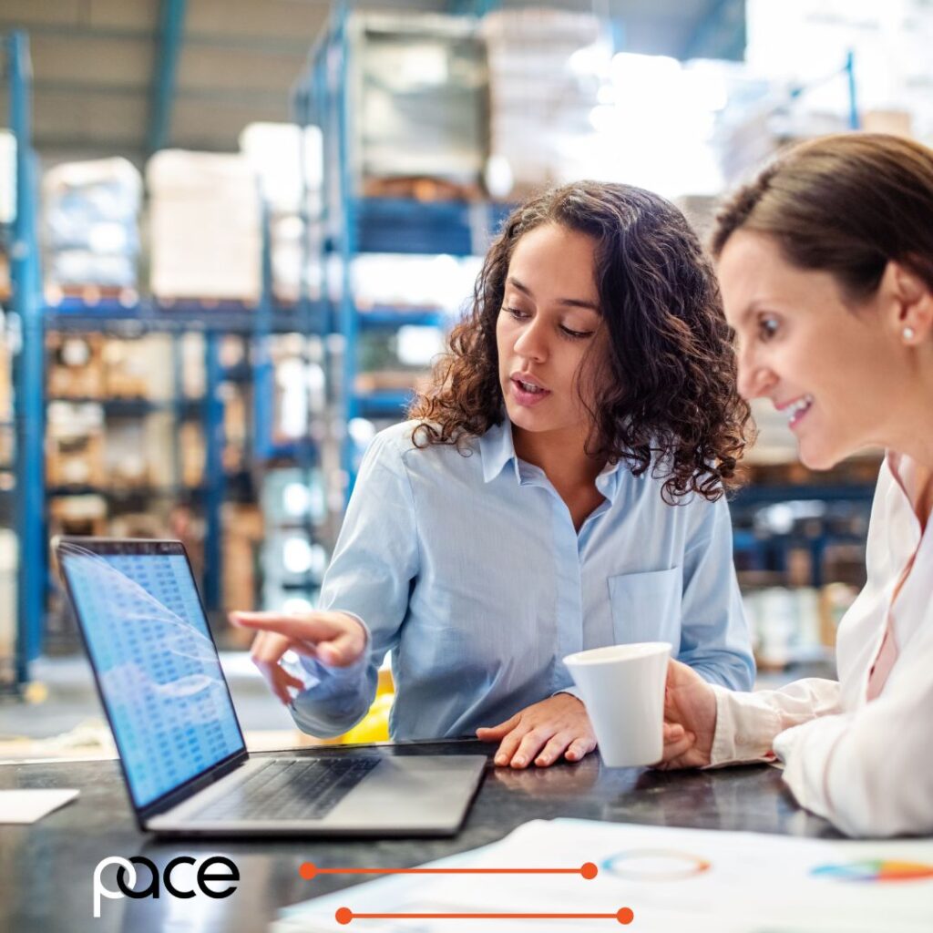 Just-in-Time versus Just-in-Case inventory management is being discussed by two women in a warehouse