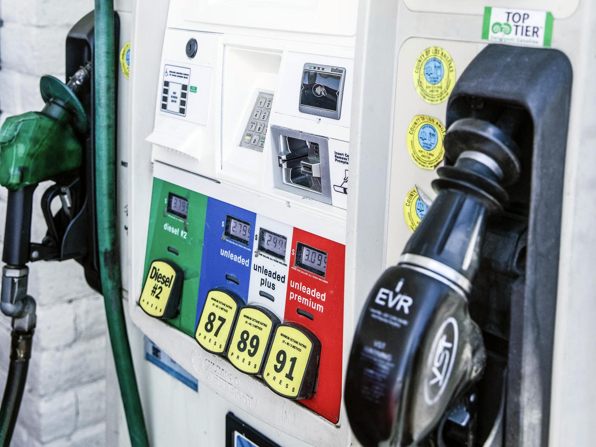 fuel pump at a gas station showing high prices for gasoline and diesel fuel