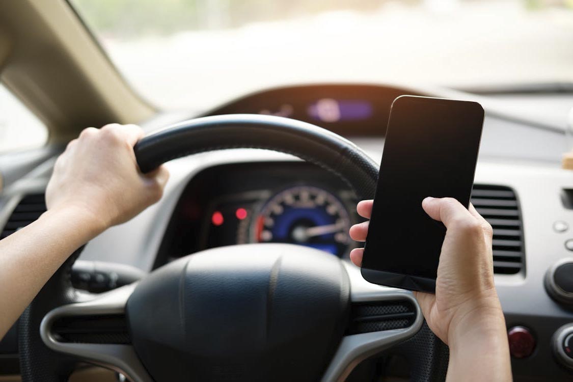 distracted driver operating a vehicle while texting on a cell phone
